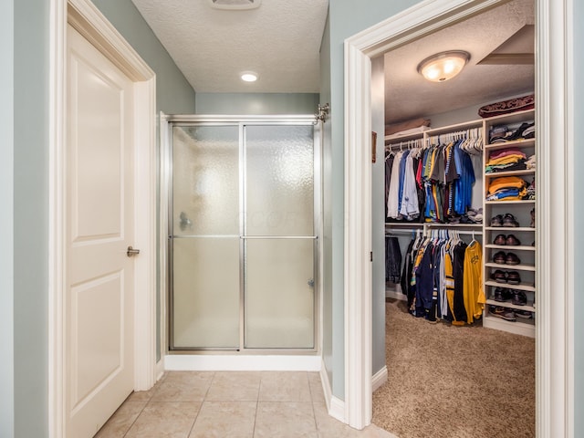 6810 Bearclover Dr, Dublin, OH 43016 - full bathroom featuring a stall shower, a textured ceiling, a walk in closet, tile patterned floors, and baseboards
