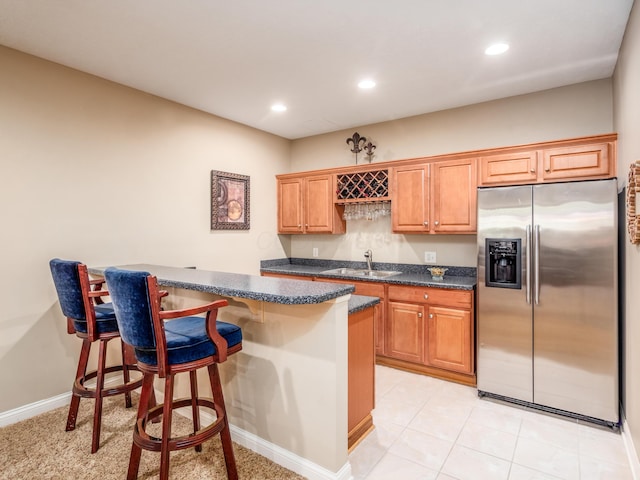 6810 Bearclover Dr, Dublin, OH 43016 - kitchen featuring stainless steel fridge, a sink, a breakfast bar area, recessed lighting, and baseboards