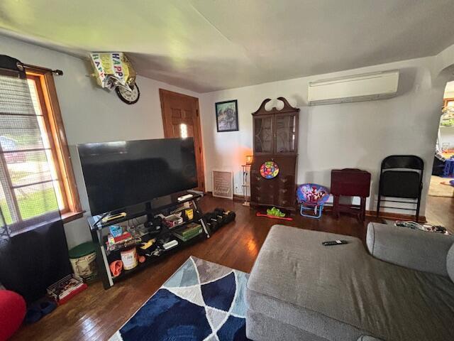 142 6th Ave, Buckeye Lake, OH 43008 - living room featuring a wall mounted air conditioner, healthy amount of natural light, and wood finished floors
