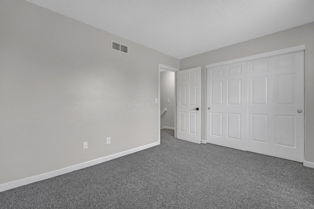 2523 Dahlia Way Unit 63B, Columbus, OH 43235 - unfurnished bedroom with dark colored carpet, baseboards, a textured ceiling, and a closet