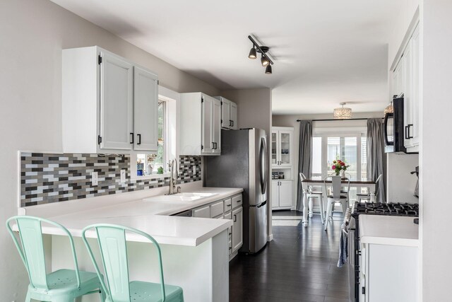 5999 Waterview Dr, Hilliard, OH 43026 - kitchen with stainless steel appliances, a sink, decorative backsplash, a peninsula, and light countertops