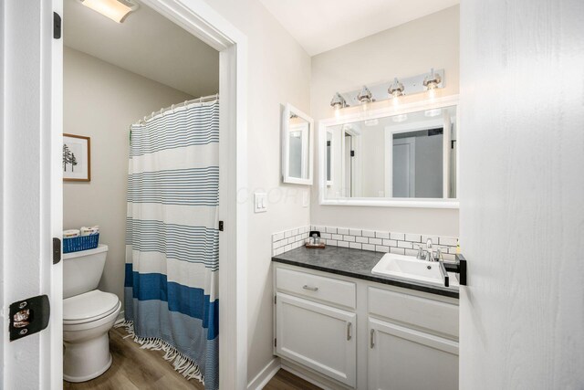 5999 Waterview Dr, Hilliard, OH 43026 - full bath featuring toilet, vanity, wood finished floors, backsplash, and a shower with curtain
