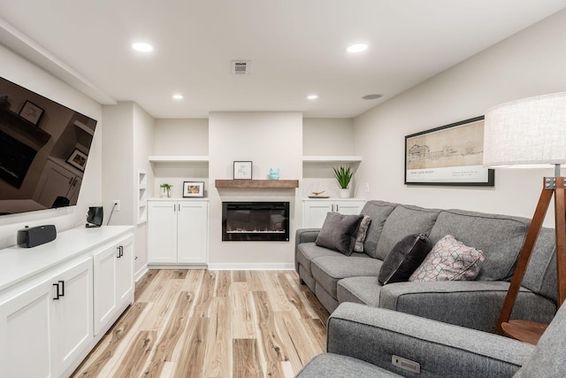 5999 Waterview Dr, Hilliard, OH 43026 - living room featuring light wood finished floors, a glass covered fireplace, and recessed lighting