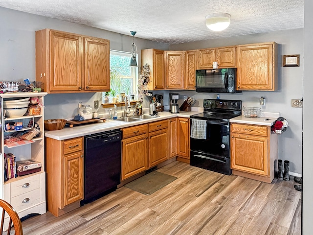 4890 Township Road 138 NW, Somerset, OH 43783 - kitchen with black appliances, a textured ceiling, light wood finished floors, and light countertops
