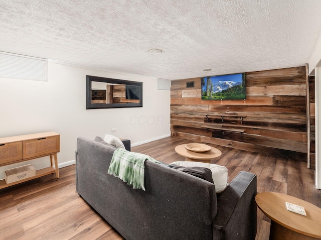 2805 Brandon Rd, Upper Arlington, OH 43221 - living room featuring wooden walls, a textured ceiling, light wood-style floors, and baseboards