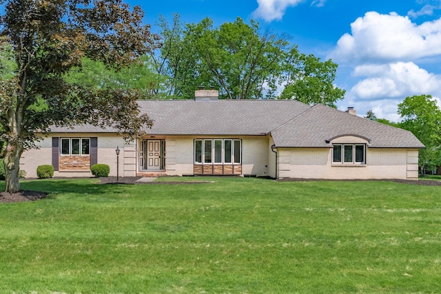 337 Naiche Ct, Columbus, OH 43213 - view of front of home with brick siding, a chimney, a front lawn, and a shingled roof