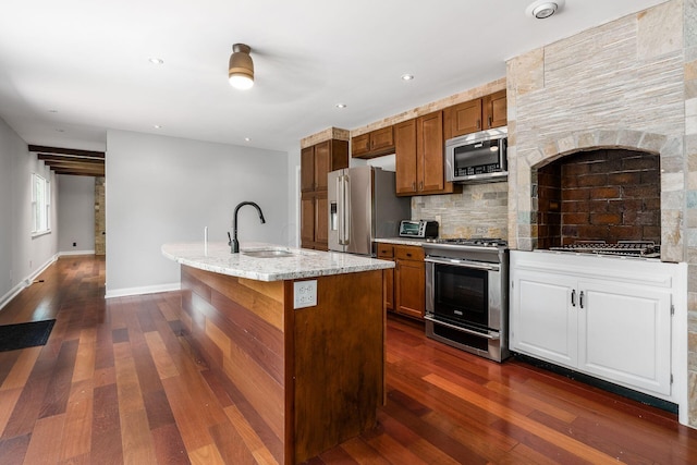 337 Naiche Ct, Columbus, OH 43213 - kitchen featuring appliances with stainless steel finishes, decorative backsplash, dark wood-style flooring, a kitchen island with sink, and recessed lighting