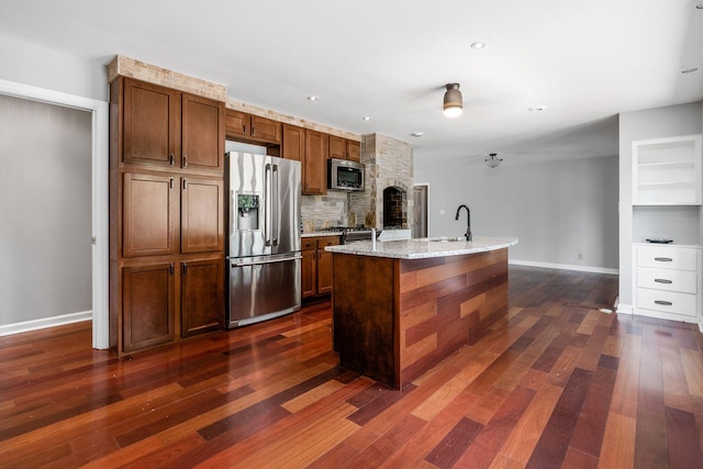 337 Naiche Ct, Columbus, OH 43213 - kitchen with stainless steel appliances, tasteful backsplash, dark wood finished floors, an island with sink, and light stone countertops