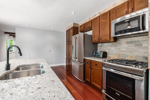 337 Naiche Ct, Columbus, OH 43213 - kitchen featuring appliances with stainless steel finishes, decorative backsplash, light stone counters, dark wood-type flooring, and brown cabinetry