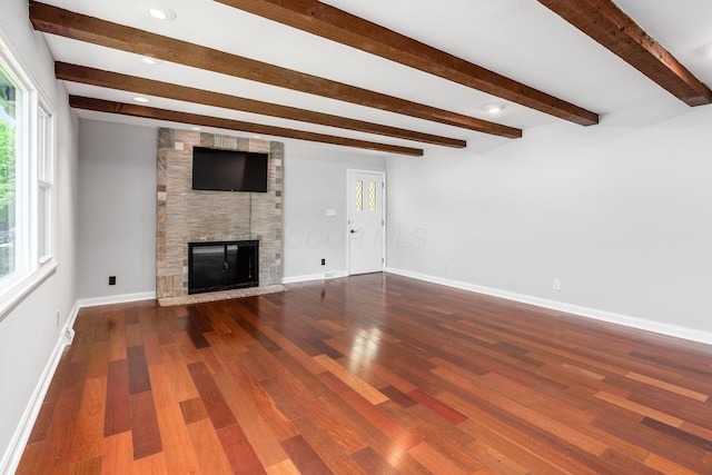 337 Naiche Ct, Columbus, OH 43213 - unfurnished living room featuring a large fireplace, plenty of natural light, beamed ceiling, and wood finished floors