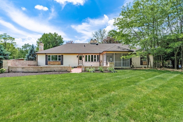 337 Naiche Ct, Columbus, OH 43213 - rear view of house with a chimney, a sunroom, a lawn, and stucco siding