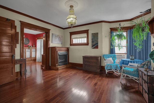 132 Orange St, Galion, OH 44833 - living area featuring wood-type flooring, a glass covered fireplace, baseboards, a chandelier, and crown molding