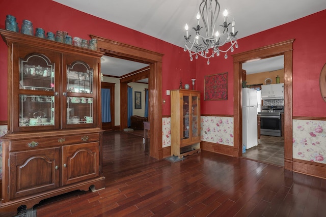 132 Orange St, Galion, OH 44833 - unfurnished dining area with wainscoting, a chandelier, wallpapered walls, wood finished floors, and baseboards