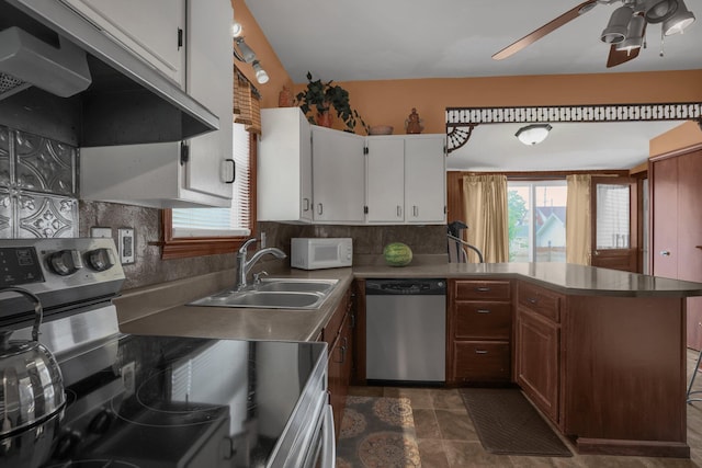 132 Orange St, Galion, OH 44833 - kitchen featuring appliances with stainless steel finishes, a sink, exhaust hood, a ceiling fan, and decorative backsplash
