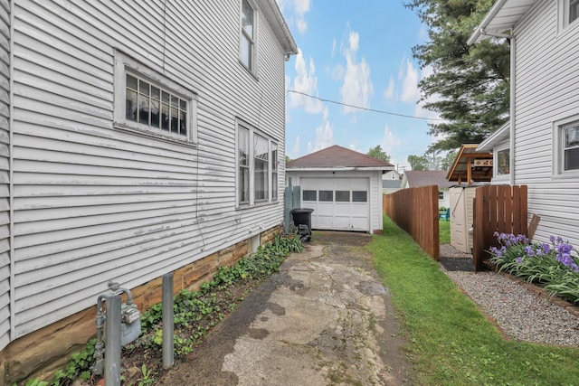 132 Orange St, Galion, OH 44833 - view of side of home featuring asphalt driveway, a garage, and an outbuilding