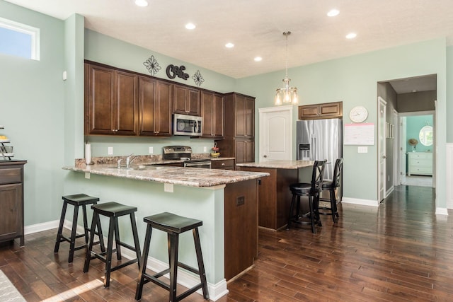 340 Olentangy W, Delaware, OH 43015 - kitchen with stainless steel appliances, a kitchen bar, dark wood-style floors, recessed lighting, and light stone countertops
