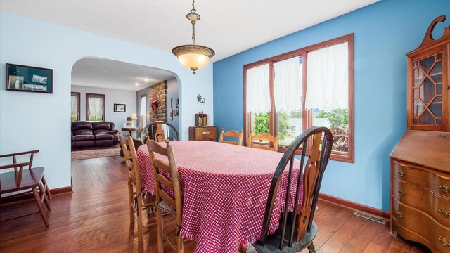 102 Sequoia Dr, Byesville, OH 43723 - dining space with arched walkways, baseboards, and dark wood finished floors