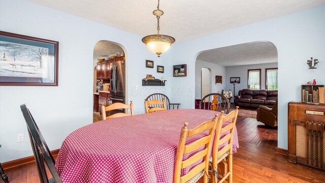 102 Sequoia Dr, Byesville, OH 43723 - dining room with arched walkways, light wood-style floors, and baseboards