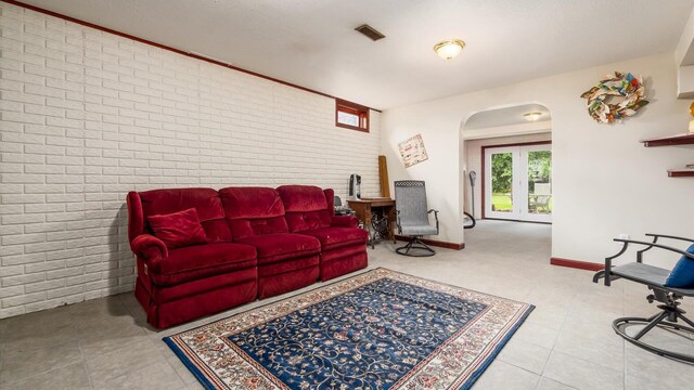 102 Sequoia Dr, Byesville, OH 43723 - living room featuring brick wall, arched walkways, tile patterned floors, and baseboards