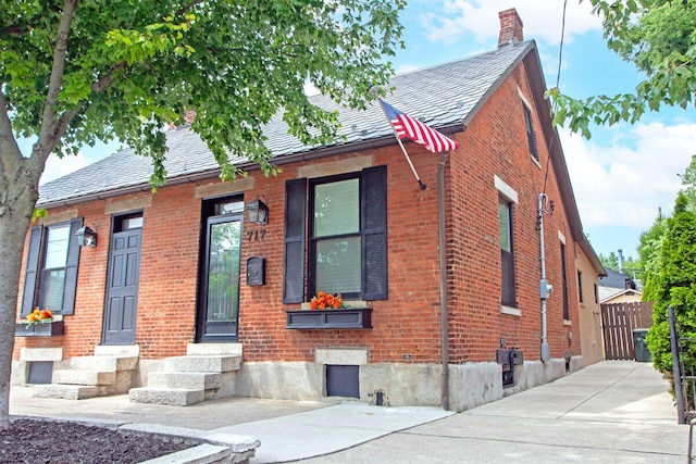 717 S 3rd St, Columbus, OH 43206 - view of front facade with entry steps, brick siding, and a chimney