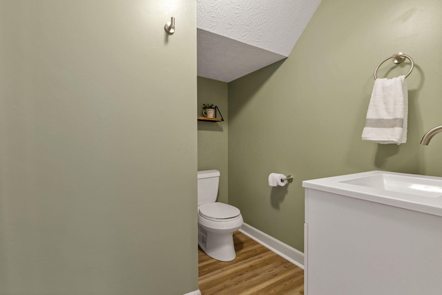 1442 S 4th St, Columbus, OH 43207 - half bath featuring vanity, wood finished floors, toilet, baseboards, and a textured ceiling