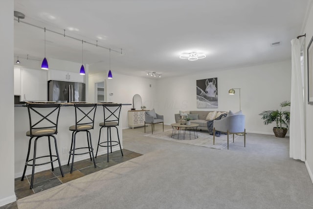 1631 Roxbury Rd Unit B6, Columbus, OH 43212 - kitchen with freestanding refrigerator, a breakfast bar, pendant lighting, white cabinets, and baseboards