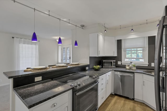 1631 Roxbury Rd Unit B6, Columbus, OH 43212 - kitchen with stainless steel appliances, a peninsula, white cabinetry, and dark stone counters
