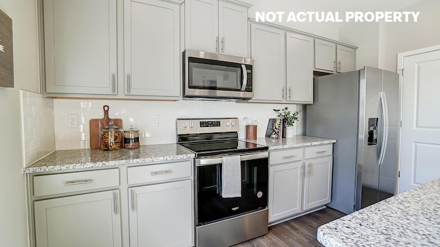 1420 Chrisman Dr, Columbus, OH 43223 - kitchen with stainless steel appliances, dark wood finished floors, tasteful backsplash, and light stone countertops