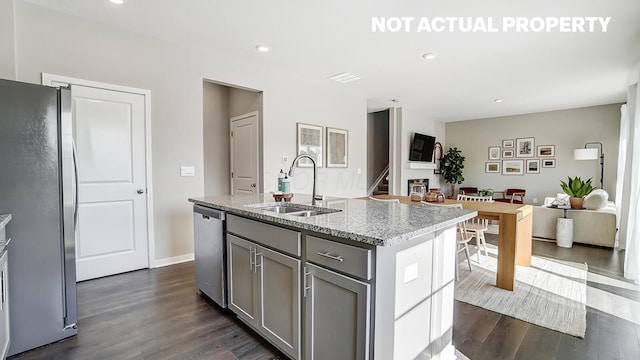 1420 Chrisman Dr, Columbus, OH 43223 - kitchen featuring a sink, appliances with stainless steel finishes, gray cabinetry, dark wood-style flooring, and a center island with sink