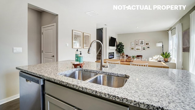 1420 Chrisman Dr, Columbus, OH 43223 - kitchen with stainless steel dishwasher, a sink, light stone countertops, open floor plan, and dark wood-type flooring