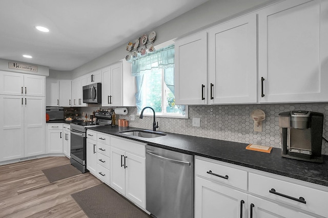 244 Shepper Ave, Plain City, OH 43064 - kitchen featuring stainless steel appliances, a sink, white cabinets, dark countertops, and light wood finished floors
