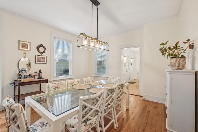 436 Beck St, Columbus, OH 43206 - dining room with light wood-type flooring, crown molding, a chandelier, and baseboards