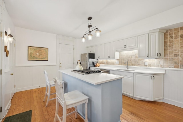 436 Beck St, Columbus, OH 43206 - kitchen featuring stainless steel appliances, a sink, light wood-type flooring, a kitchen breakfast bar, and white cabinets