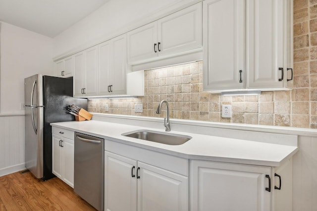 436 Beck St, Columbus, OH 43206 - kitchen with a sink, appliances with stainless steel finishes, light wood-type flooring, white cabinets, and wainscoting