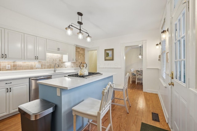 436 Beck St, Columbus, OH 43206 - kitchen featuring stainless steel appliances, white cabinets, a kitchen island, and backsplash