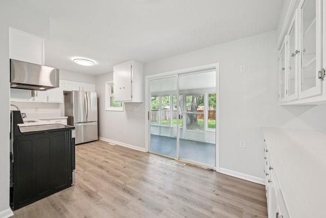 106 Woodrow Ave, Delaware, OH 43015 - kitchen with freestanding refrigerator, exhaust hood, white cabinets, baseboards, and washer / dryer