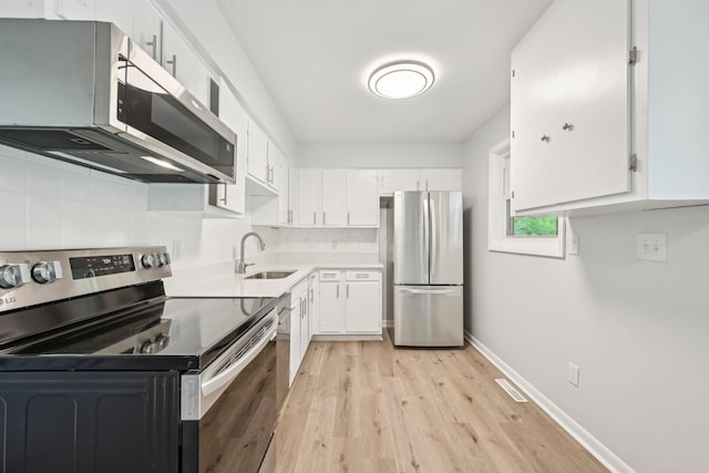 106 Woodrow Ave, Delaware, OH 43015 - kitchen with appliances with stainless steel finishes, a sink, light wood-style floors, and white cabinets