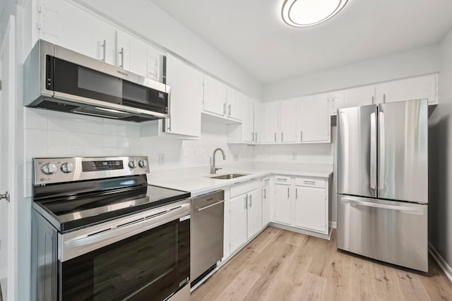 106 Woodrow Ave, Delaware, OH 43015 - kitchen with stainless steel appliances, a sink, light countertops, white cabinets, and light wood-style flooring
