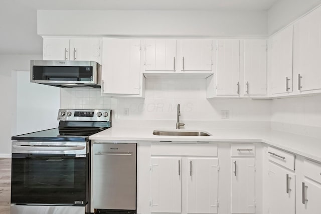 106 Woodrow Ave, Delaware, OH 43015 - kitchen with appliances with stainless steel finishes, a sink, white cabinetry, tasteful backsplash, and light countertops