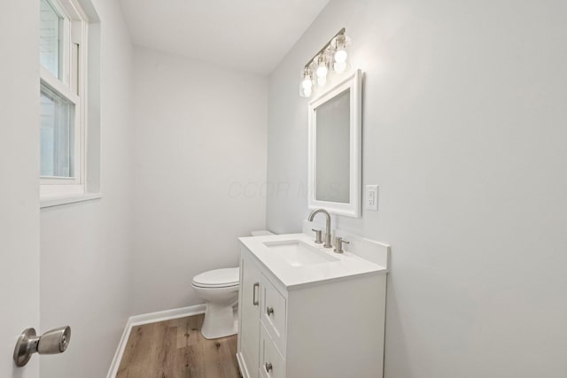 106 Woodrow Ave, Delaware, OH 43015 - half bathroom featuring toilet, wood finished floors, vanity, and baseboards