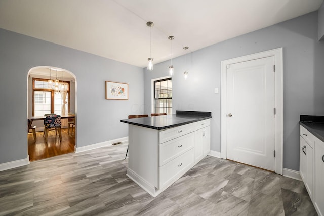 141 S Kellner Rd, Columbus, OH 43209 - kitchen featuring dark countertops, a peninsula, arched walkways, and plenty of natural light