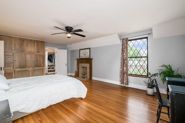 141 S Kellner Rd, Columbus, OH 43209 - bedroom featuring wood finished floors, a fireplace with flush hearth, ceiling fan, and a walk in closet