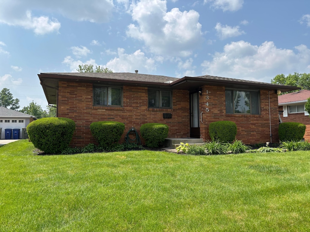 1345 Molly Ln, Columbus, OH 43207 - view of front facade featuring brick siding and a front lawn