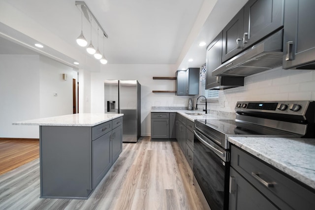 1345 Molly Ln, Columbus, OH 43207 - kitchen featuring appliances with stainless steel finishes, open shelves, under cabinet range hood, a kitchen island, and light wood finished floors