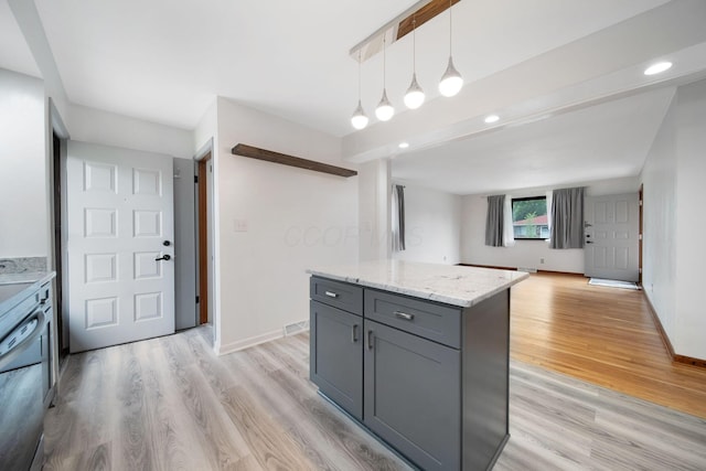 1345 Molly Ln, Columbus, OH 43207 - kitchen featuring gray cabinetry, light wood-style flooring, decorative light fixtures, light stone countertops, and a center island