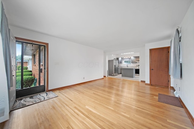1345 Molly Ln, Columbus, OH 43207 - unfurnished living room featuring light wood-style floors and a chandelier