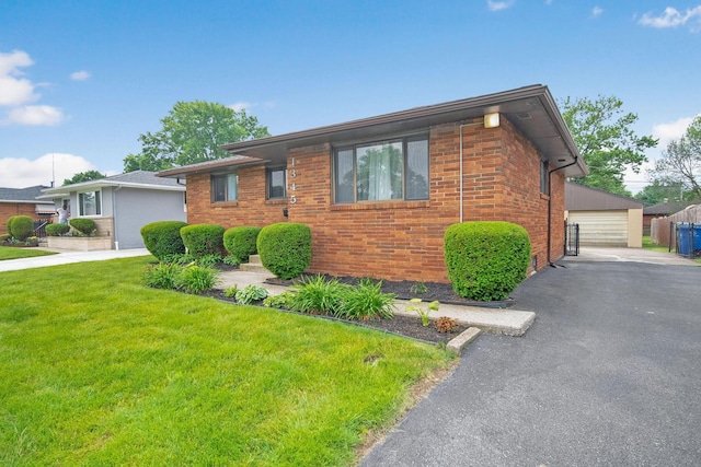 1345 Molly Ln, Columbus, OH 43207 - view of front of home featuring a front yard, a garage, brick siding, and an outbuilding