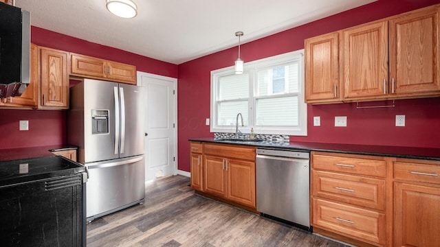 422 N Cedar St, Newark, OH 43055 - kitchen with appliances with stainless steel finishes, a sink, dark wood-type flooring, dark countertops, and hanging light fixtures