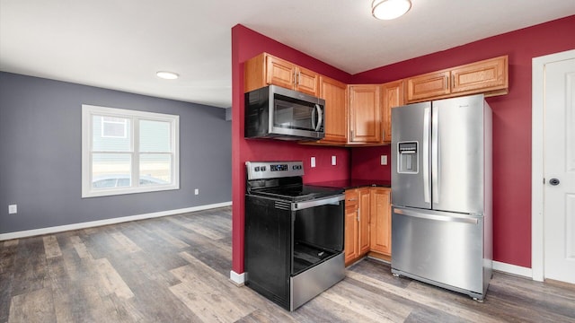 422 N Cedar St, Newark, OH 43055 - kitchen with stainless steel appliances, light wood-style floors, baseboards, and dark countertops