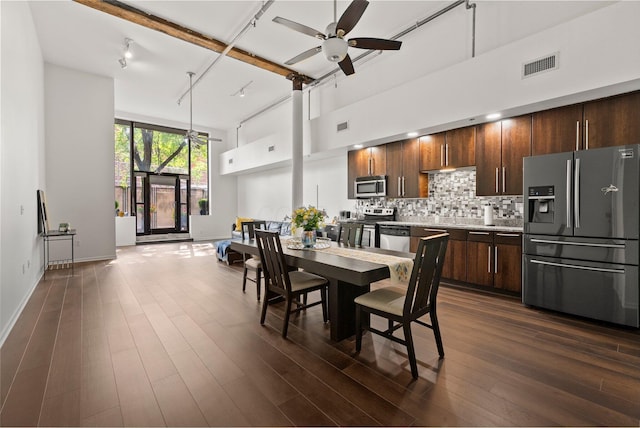 78 E Chestnut St Unit 107, Columbus, OH 43215 - dining space with ceiling fan, a towering ceiling, baseboards, and dark wood finished floors